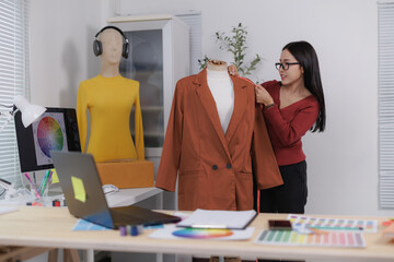 Fashion designer taking measurements of jacket on mannequin in creative studio