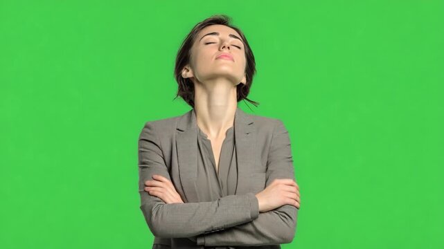 Poised in Thought: A serene female figure, dressed in formal attire, stands with crossed arms, eyes closed, as she meditates with quiet introspection.