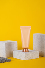 Plastic white tube for cream or lotion. Skin care or sunscreen cosmetic with stylish props on...