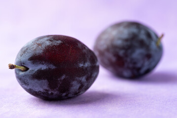 Fresh blue plum fruit on purple background