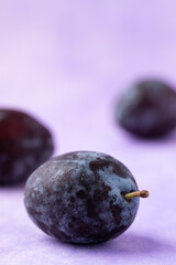 Fresh blue plum fruit on purple background