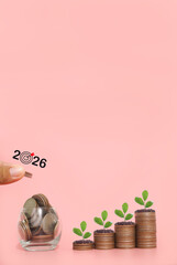 Hand putting coin into glass bottle and plants growing up on stack of coins. The concept of saving money, Financial, Investment and Business growing in year 2026.