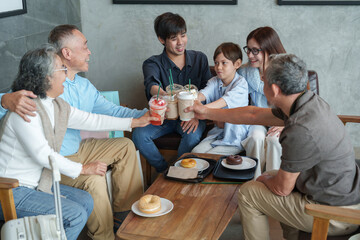 group of the generations family clinking coffee cups together at cafe and bakery