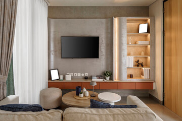 Modern living room interior with a TV mounted on a concrete-textured wall. Features a built-in...