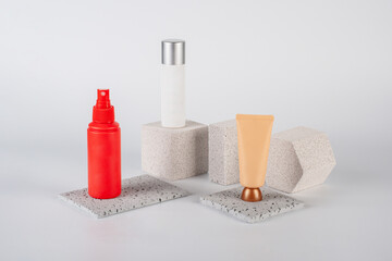 Plastic white tube for cream or lotion. Skin care or sunscreen cosmetic, Cosmetic red bottle. Womens cosmetic accessory for makeup with stylish props on white background.