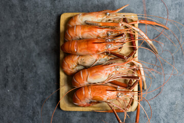Boiled King prawns river prawns served on wood tray. Top view