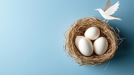 Top view of delicate eggs in paper nest on soft blue background with paper bird flying above