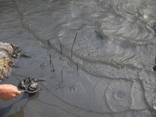Laying down the raw Onsen Tamago or hot spring eggs for boiling in thermal spring