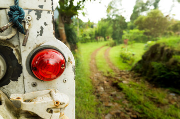 Old off-road sport utility vehicle parked on the side of trail path leading into the forest. Adventures concept.