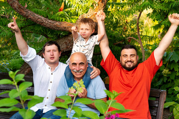 Family happily pointing and smiling together, sharing excitement and affection while sitting on a...