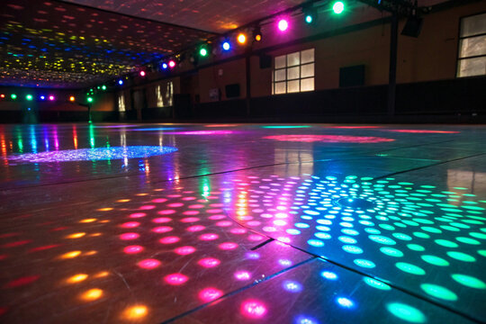 Multicolored disco lights reflected on the abstract floor.