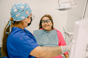 Dentist wearing surgical mask and gloves preparing patient for dental checkup