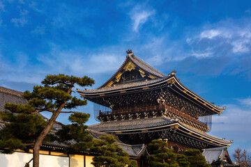 Obraz premium Main hall, Hongan-ji temple in Kyoto, Japan. Gravel yard in foreground. Blue sky, clouds overhead. 