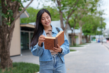 Young woman reading a book outdoors in urban setting