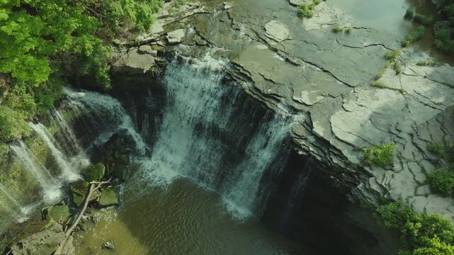 Drone zooming out from above the cliff of Upper Balls Falls revealing its full height and width.