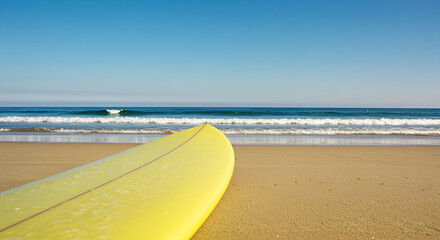 Sunny beach scene with yellow surfboard