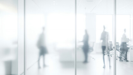 Fototapeta premium Blurred figures in a bright office space with glass walls and modern design.