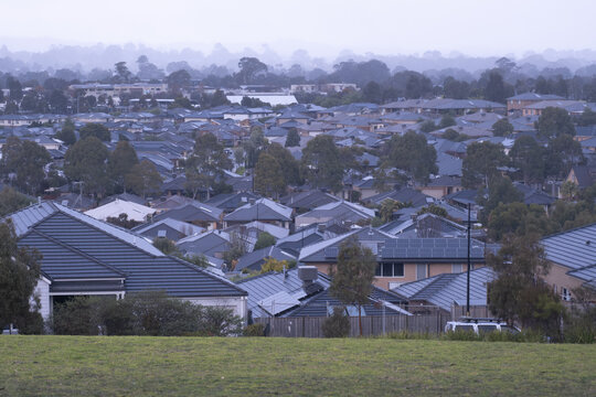 Moody winter view over the suburban rooftops of Doreen, Victoria, Australia, on a cold and rainy day.  Dense residential housing with a grey winter atmosphere in Melbourne&rsquo;s outer suburbs.