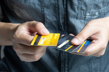 man holding several credit cards and he is choosing a credit card to pay and spend Payment for...