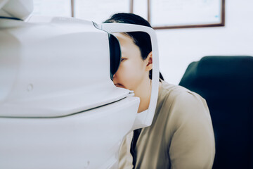 Young woman having an eye examination using a modern eye testing device