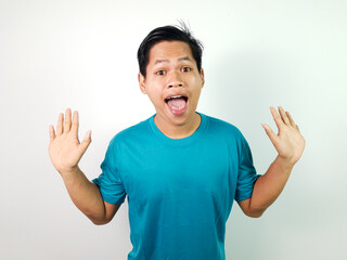 Surprised Young Asian Man Raising Hands Wearing Blue T-Shirt With White Background