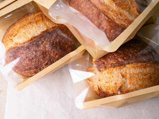 Sourdough Bread Loaf in Transparent Plastic Bag on White Background – Ready for Sale or Delivery