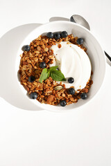 Greek Yogurt with Crispy Granola and Fresh Blueberries on White Background. Eating Healthy.	