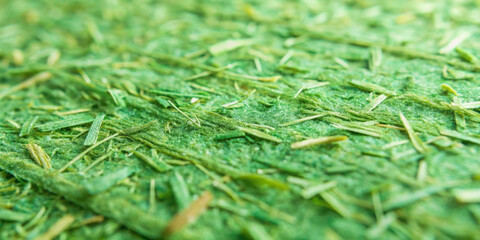 Close-up view of synthetic grass showing texture and fine green fibers under bright daylight