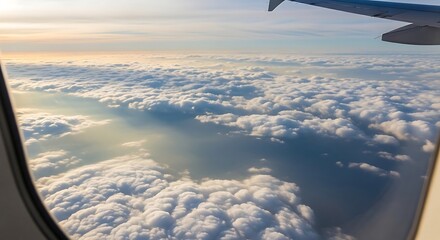 Obraz premium Aerial view of fluffy cloudscape at sunrise, seen from airplane window.