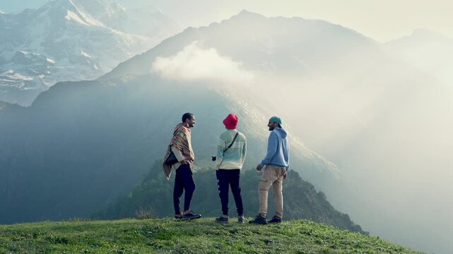 Three young men,a blonde man, a brunette man, and man wearing a red cap, consulting travel content together near the Madmaheshwar Temple trek, close to Ransi Village, Uttarakhand, India. Slow Motion.