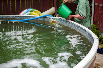 pouring chlorine into a pool