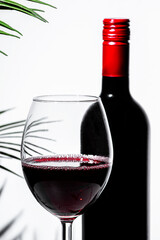Non-alcoholic red wine displayed elegantly with a glass and bottle against a minimalist background