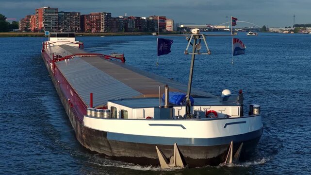 Forward drone view of Maranta container ship on Oude Maas distributary approaching the local harbor, Dordrecht, Zuid-Holland, Netherlands.