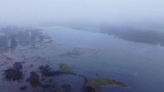 Massive floodplain submersion in Latvia seen at dawn through thick morning fog