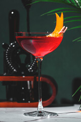 Red alcoholic cocktail drink with bitters, juice, prosecco sparkling wine and orange zest
