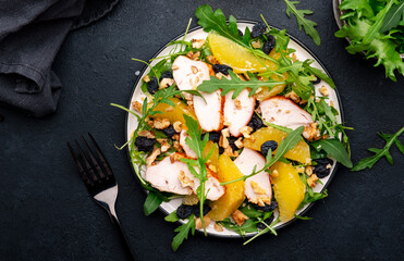 Juicy salad with grilled chicken fillet, orange slices, raisins, walnut, arugula, spinach and...