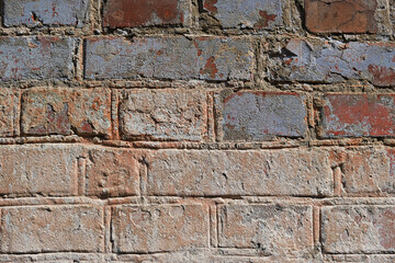 Close-up of an old brick wall with signs of aging, erosion, and natural texture variations.