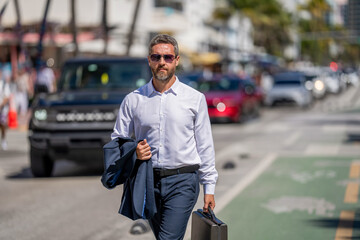 Successful businessman walking with briefcase outdoor. Businessman hold briefcase. Businessman...