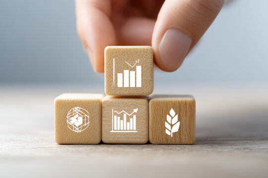 Hand placing wooden blocks with growth and global icons