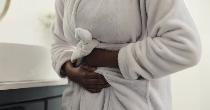 Woman, hands or stomach ache with pain in bathroom for gastro reflux or indigestion in home. Female person, cramp or sore tummy with diarrhea for constipation, bowel obstruction or infection in house