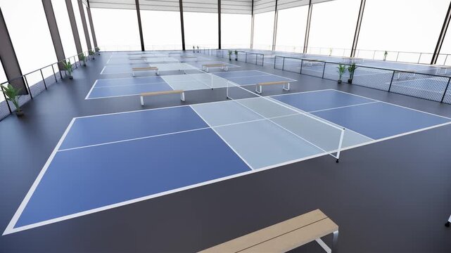 Aerial view of a pickleball court facility with blue and grey color inside warehouse building