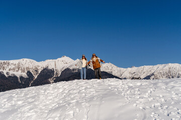 Couple Hiking Snow Mountains Winter: Joyful adventure in snowy mountain range during winter season.