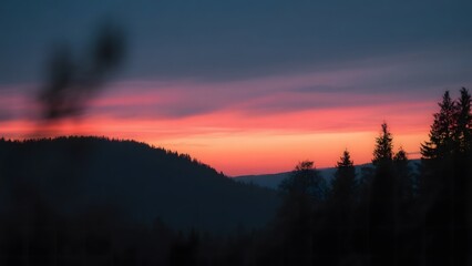 Dramatic Sunset Over Silhouetted Hills and Forest