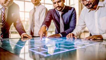 Diverse business team collaborating around a futuristic interactive digital display table