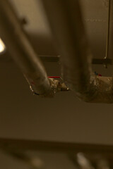 This is a detailed closeup image of a metallic pipe protruding from a circular hole that has been...