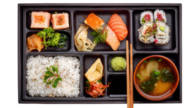 Sushi bento box featuring assorted sushi, rice, miso soup, and fresh vegetables on a black background.
