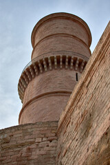 Ancient Tour du Fanal tower at Fort Saint-Jean in Marseille, emerging from the stone wall under a blue sky in Provence-Alpes-Cote d'Azur