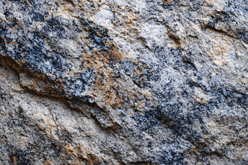 Close up of rough speckled granite stone placed on gray background