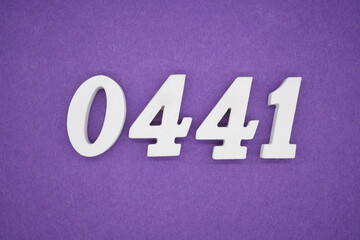 The numbers are made of white painted wood, placed on a purple paper background.
