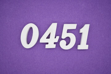 The numbers are made of white painted wood, placed on a purple paper background.